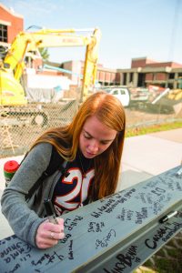 Students were invited to sign the last steel beam being installed into the Jim and Martie Bultman Student Center. Photo by Garrett Gormley.