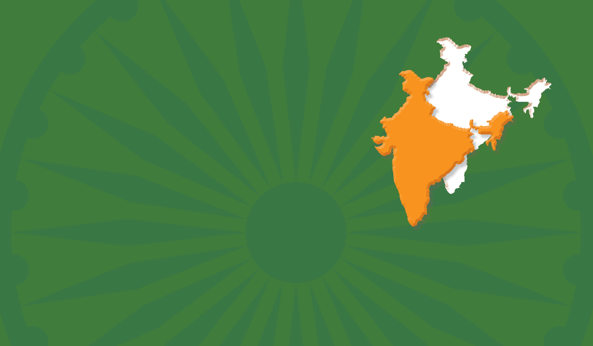 An Ashoka Chakra, the 24-spoke wheel featured in the center of the flag of India, is overlaid with a field of India green, with a saffron color shape of India cut out from the green and offset, leaving a hole in the green field.