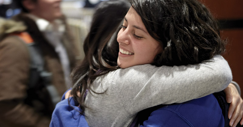 Two students embrace