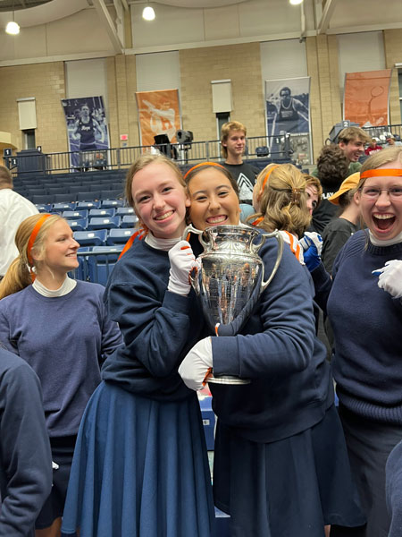 Nykerk song winners hold the Nykerk Cup, and side hug, after winning the competition.