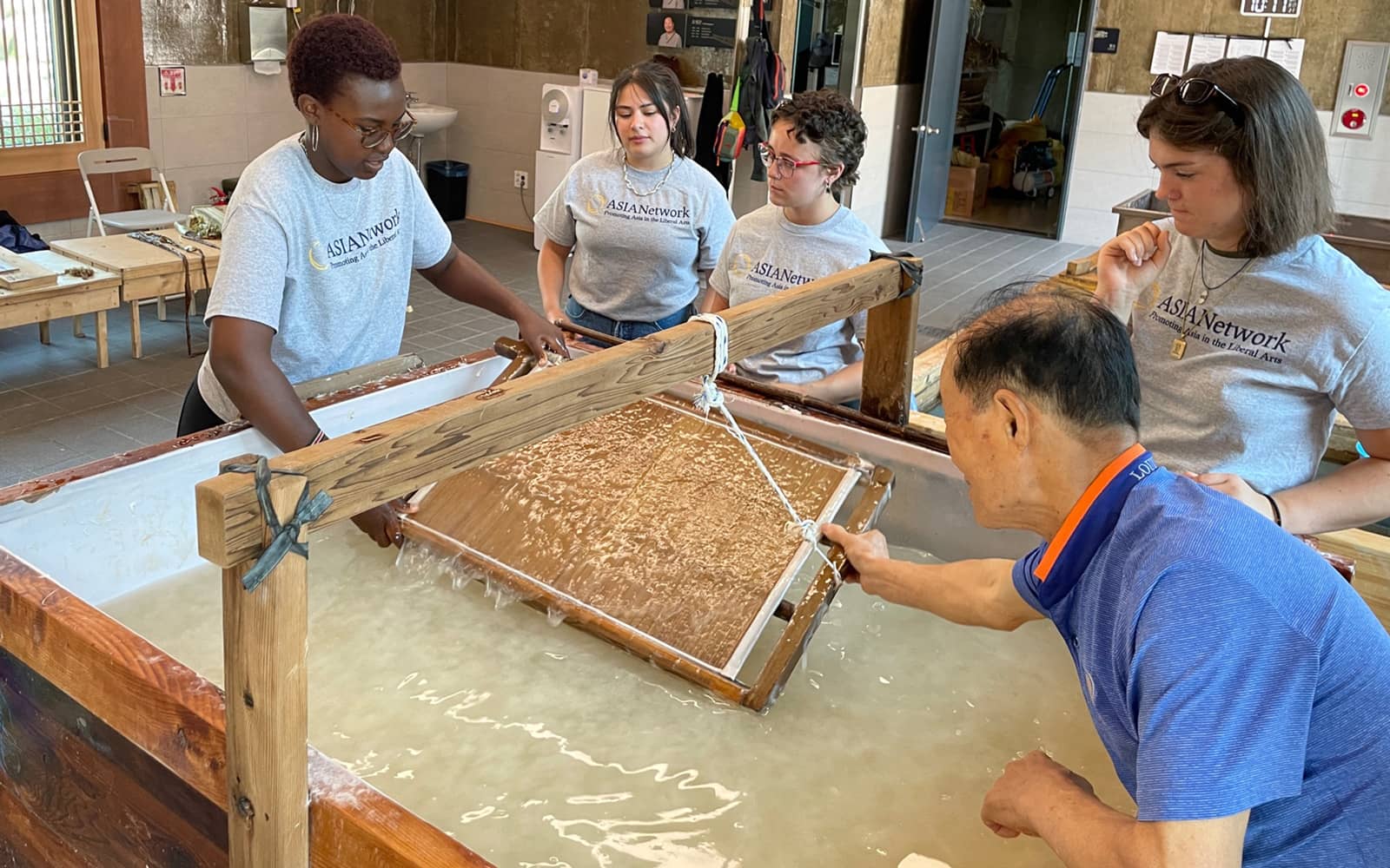At the Jeonju Millennium Hanji Museum in Seoul, master paper maker Shintae Park (at bottom right) teaches Ayanna Njoroge ’24, Madai Huerta ’23, Isabella Gaetjens-Oleson ’23 and Joanna Locke ’24, pictured from left, how to make a traditional Korean paper.